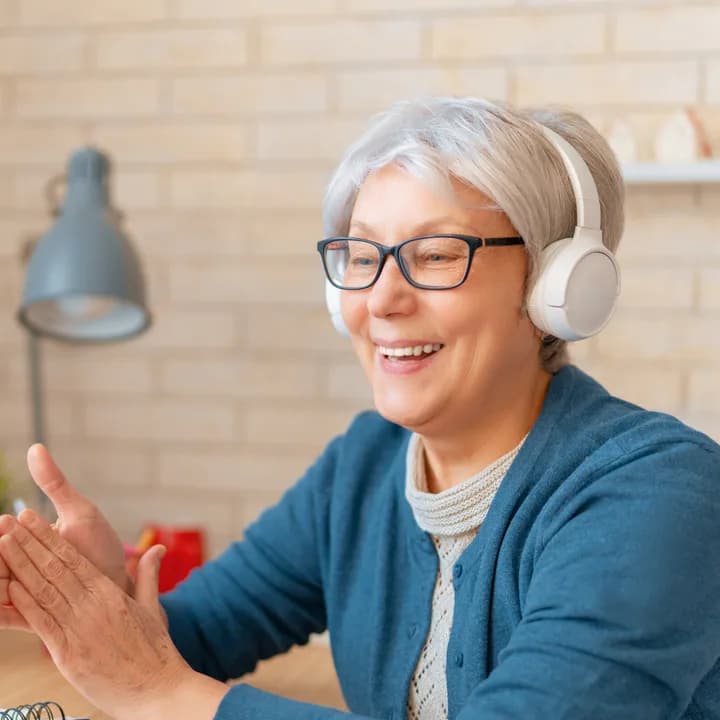 An adult student smiling during an online Spanish lesson