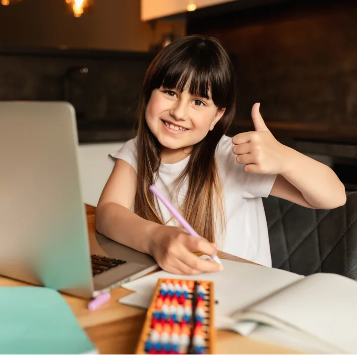 A child giving a thumbs up during a lesson